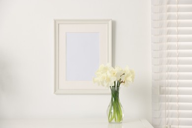 Photo of Beautiful daffodils in vase on white table at home