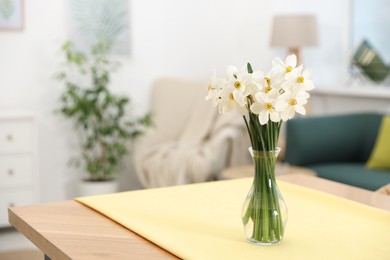 Photo of Beautiful daffodils in vase on table at home, space for text