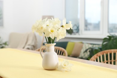 Photo of Beautiful daffodils in vase on table at home