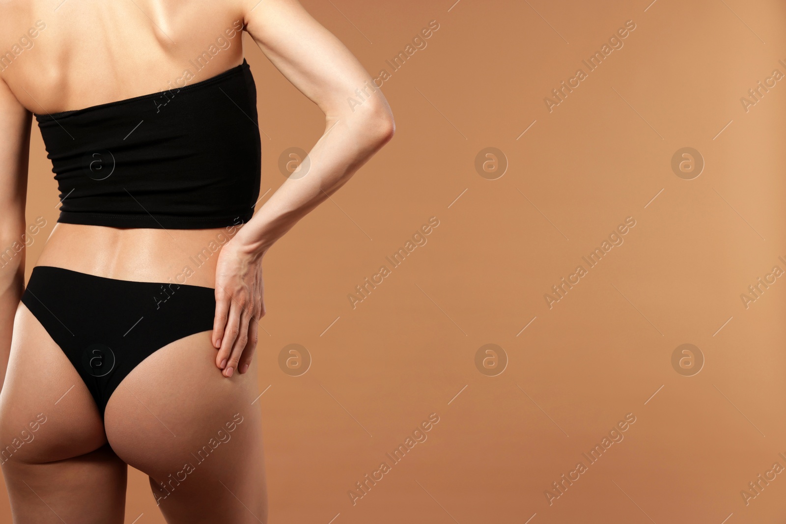 Photo of Woman with perfect slim body on beige background, closeup. Space for text