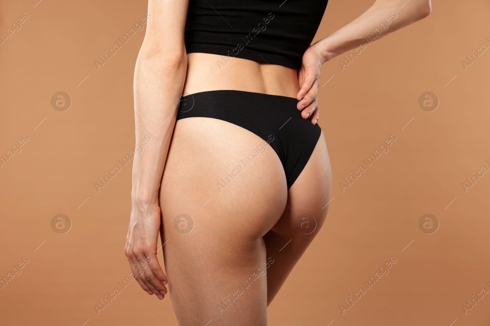 Photo of Woman with perfect slim body on beige background, closeup