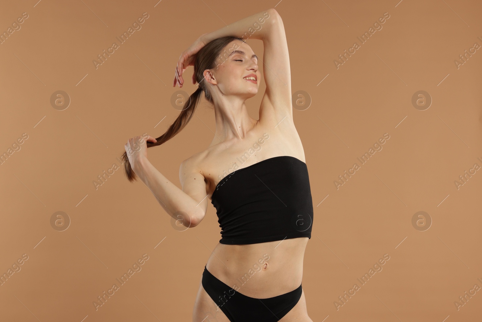 Beautiful woman with perfect slim body on beige background Photo of Beautiful woman with perfect slim body on beige background