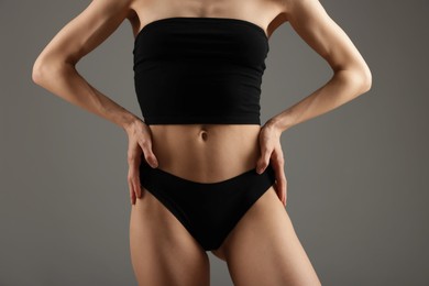 Photo of Woman with perfect slim body on grey background, closeup