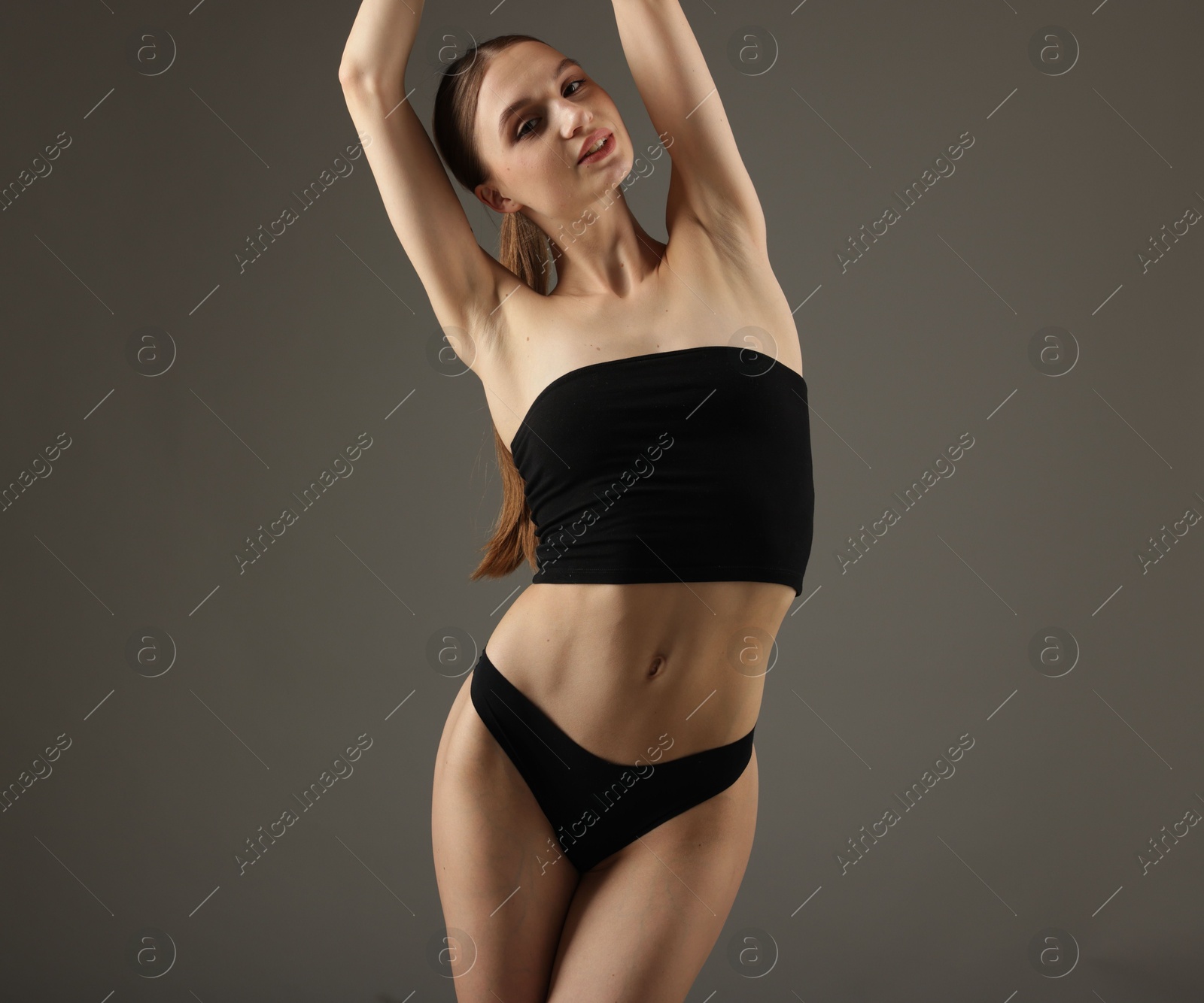 Beautiful woman with perfect slim body on grey background Photo of Beautiful woman with perfect slim body on grey background