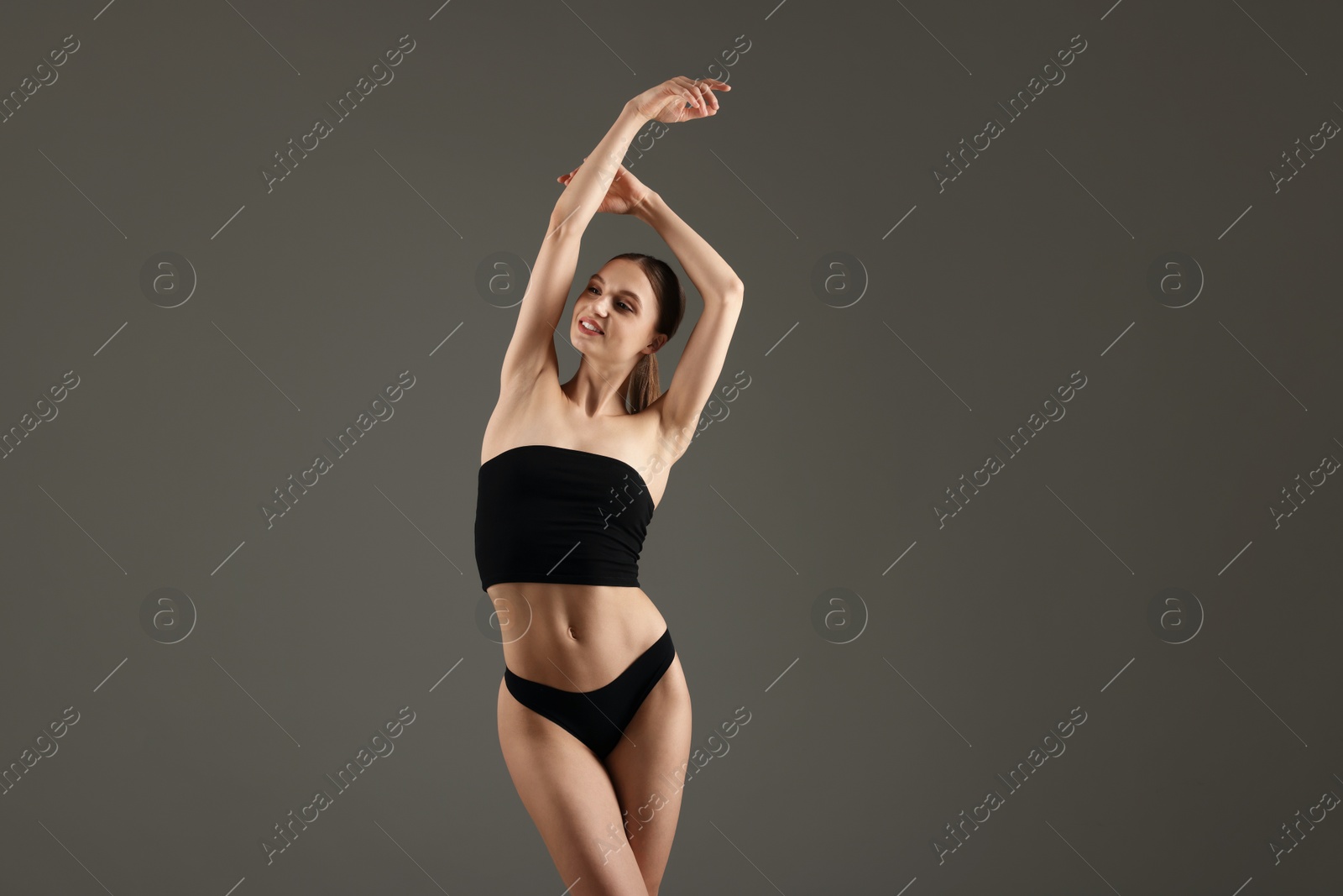 Photo of Beautiful woman with perfect slim body on grey background. Space for text