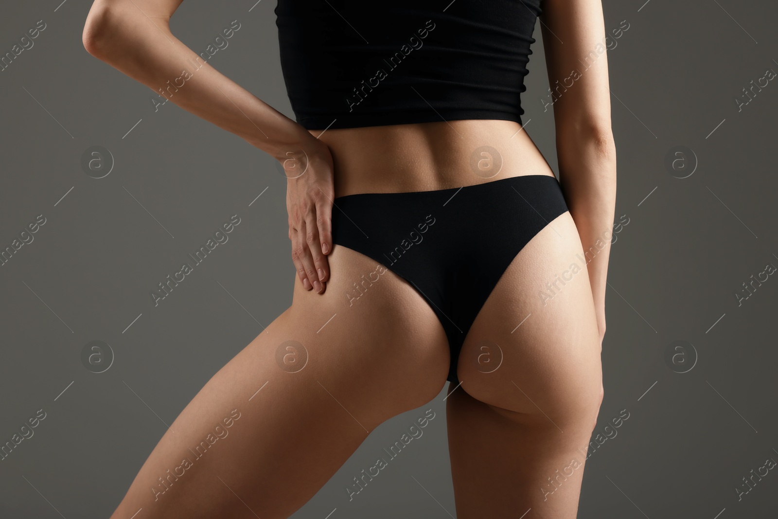 Woman with perfect slim body on grey background, closeup Photo of Woman with perfect slim body on grey background, closeup