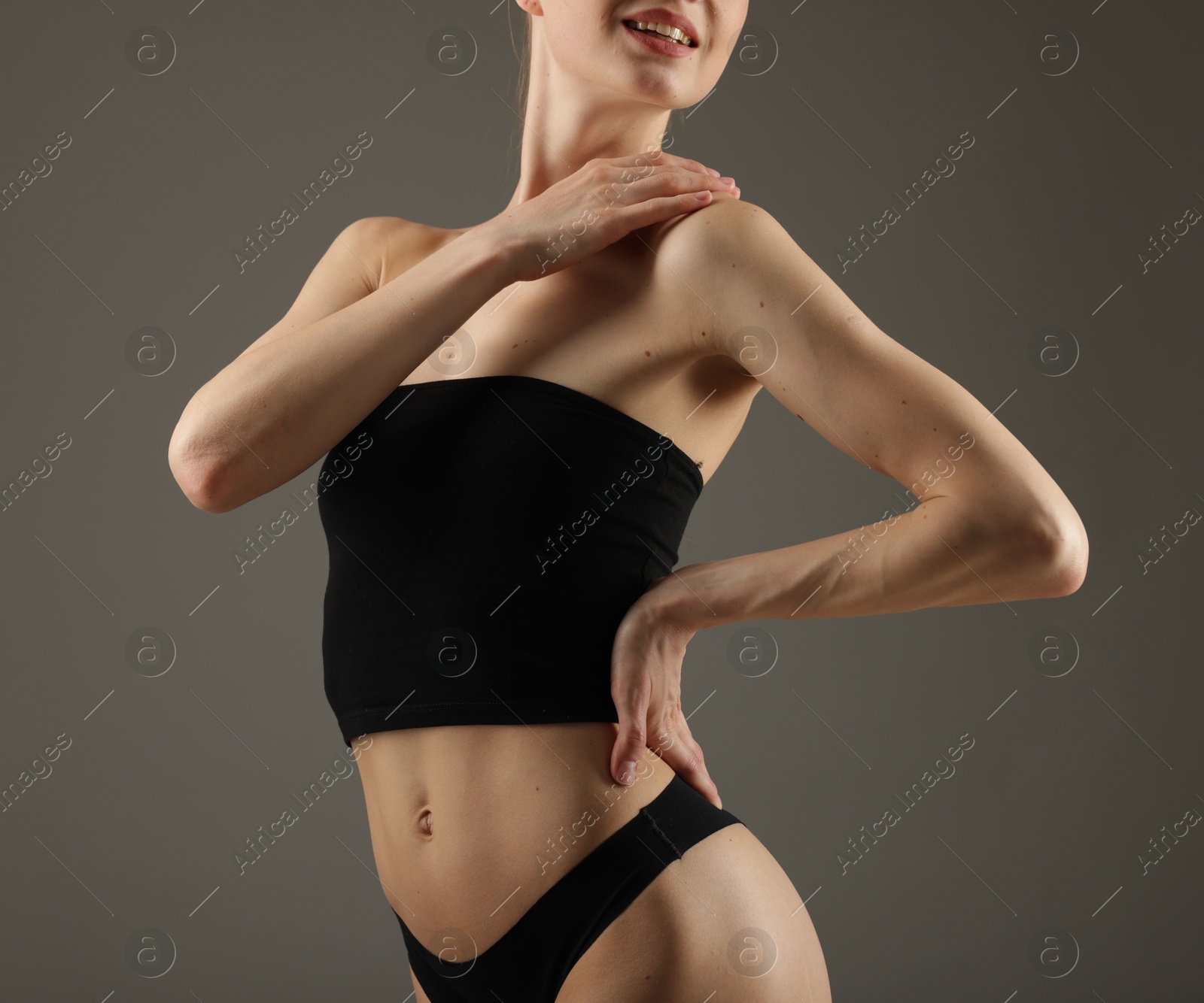 Photo of Woman with perfect slim body on grey background, closeup