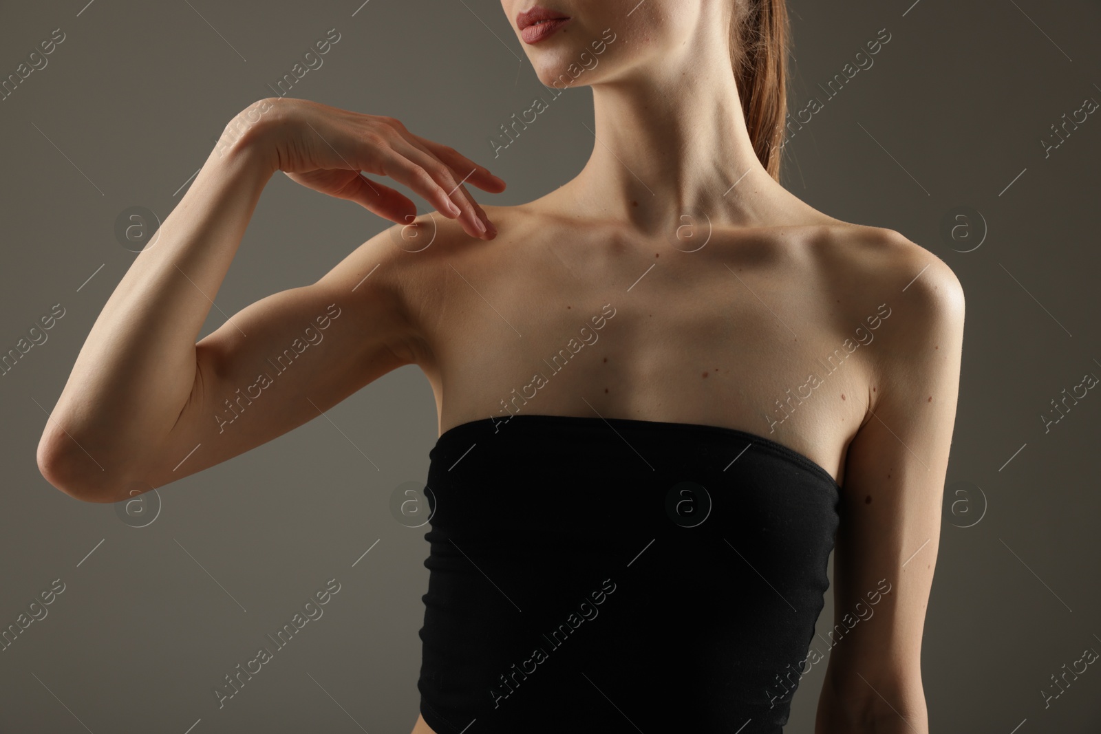 Woman with perfect slim body on grey background, closeup Photo of Woman with perfect slim body on grey background, closeup