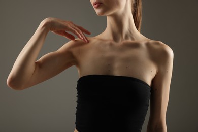 Photo of Woman with perfect slim body on grey background, closeup