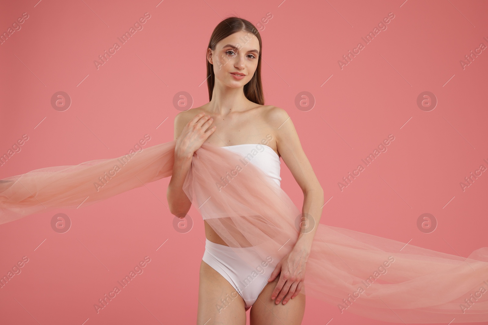Young woman with beautiful fabric on pink background Photo of Young woman with beautiful fabric on pink background