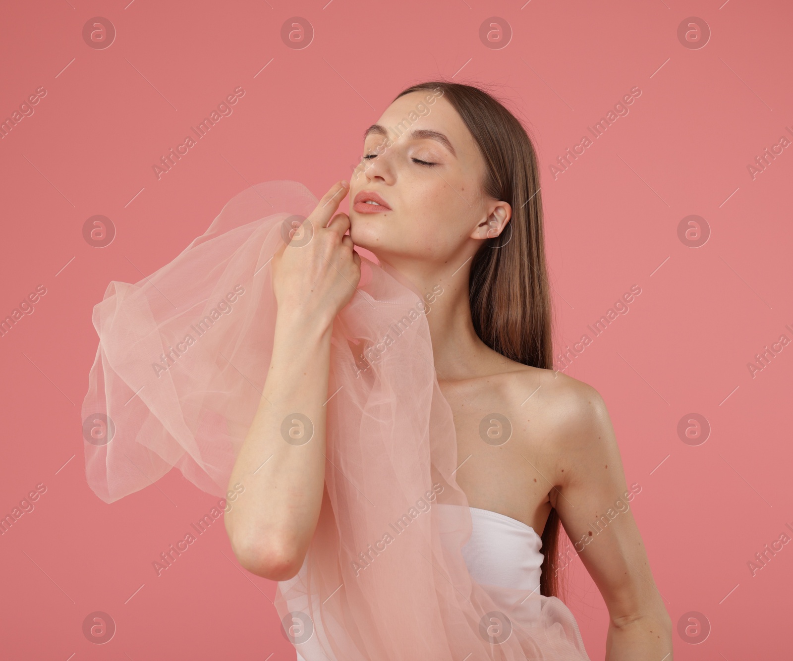 Young woman with beautiful fabric on pink background Photo of Young woman with beautiful fabric on pink background