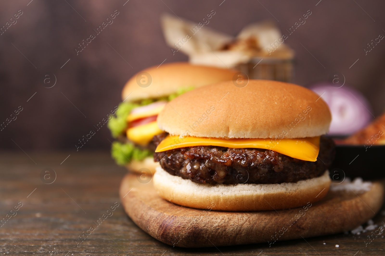 Tasty cheeseburgers on wooden table, closeup. Space for text Photo of Tasty cheeseburgers on wooden table, closeup. Space for text