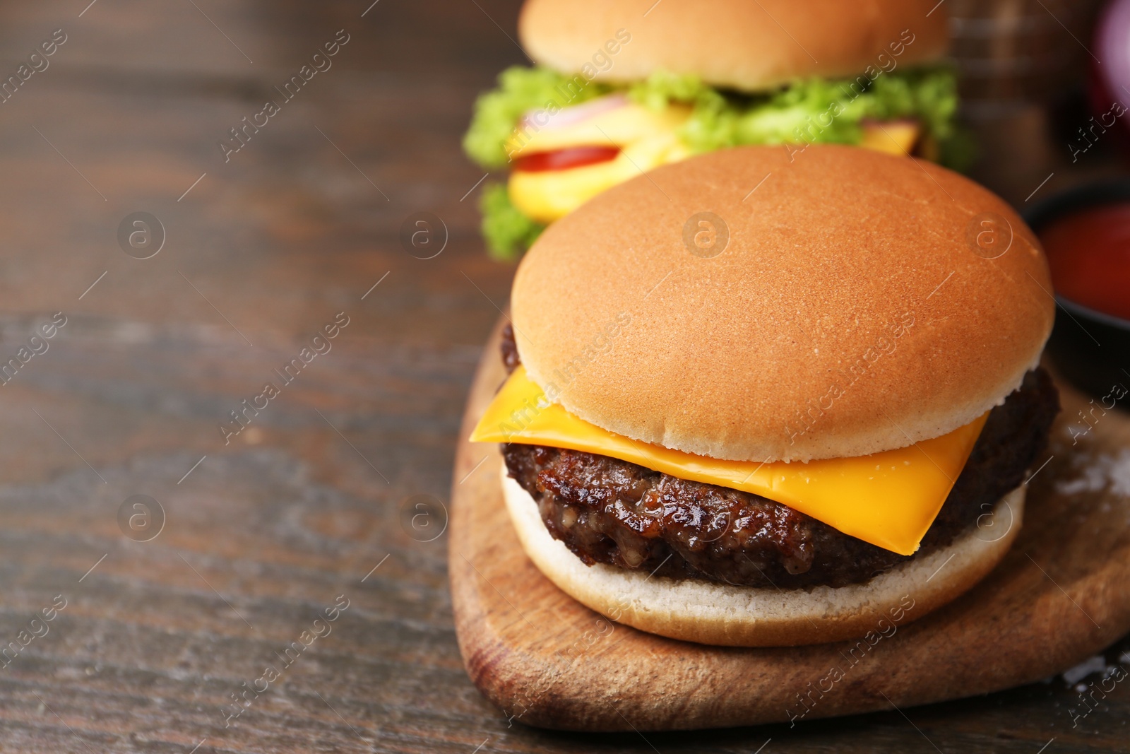 Tasty cheeseburgers on wooden table, closeup. Space for text Photo of Tasty cheeseburgers on wooden table, closeup. Space for text