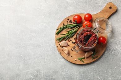 Photo of Delicious sun dried tomatoes, fresh vegetables, rosemary and garlic on light grey table, top view. Space for text