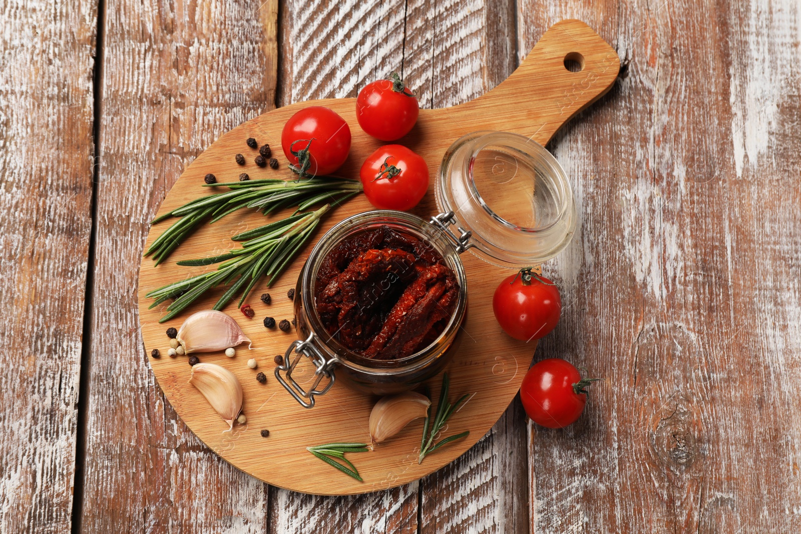 Delicious sun dried tomatoes, fresh vegetables, rosemary and garlic on wooden table, top view Photo of Delicious sun dried tomatoes, fresh vegetables, rosemary and garlic on wooden table, top view