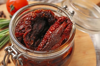 Photo of Delicious sun dried tomatoes in jar on table, closeup