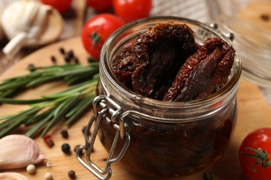 Photo of Delicious sun dried tomatoes in jar on table, closeup