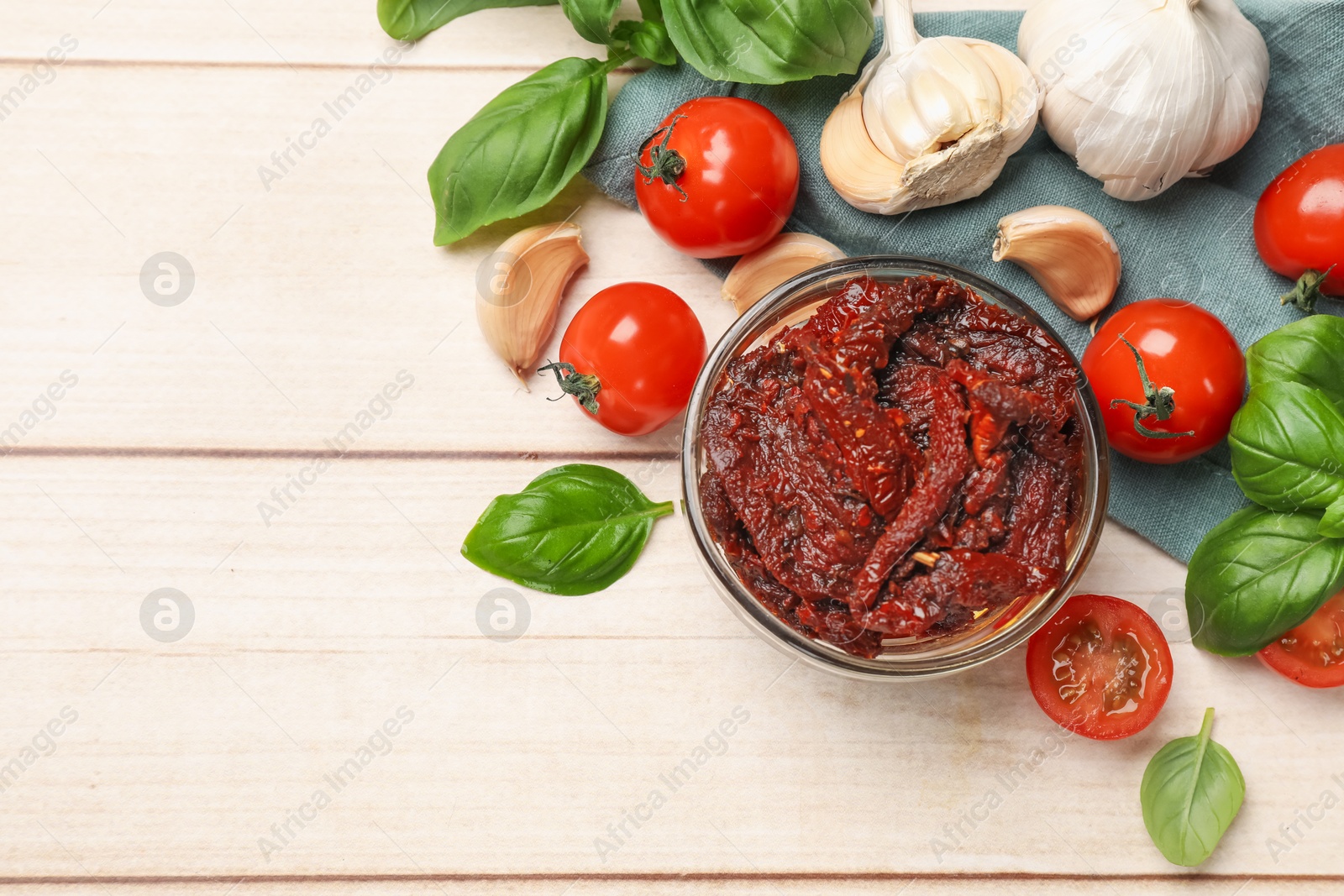 Delicious sun dried tomatoes, fresh vegetables, basil and garlic on white wooden table, flat lay. Space for text Photo of Delicious sun dried tomatoes, fresh vegetables, basil and garlic on white wooden table, flat lay. Space for text