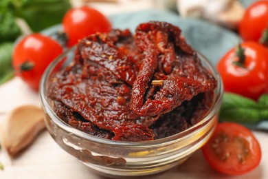 Photo of Delicious sun dried tomatoes and fresh vegetables on white table, closeup