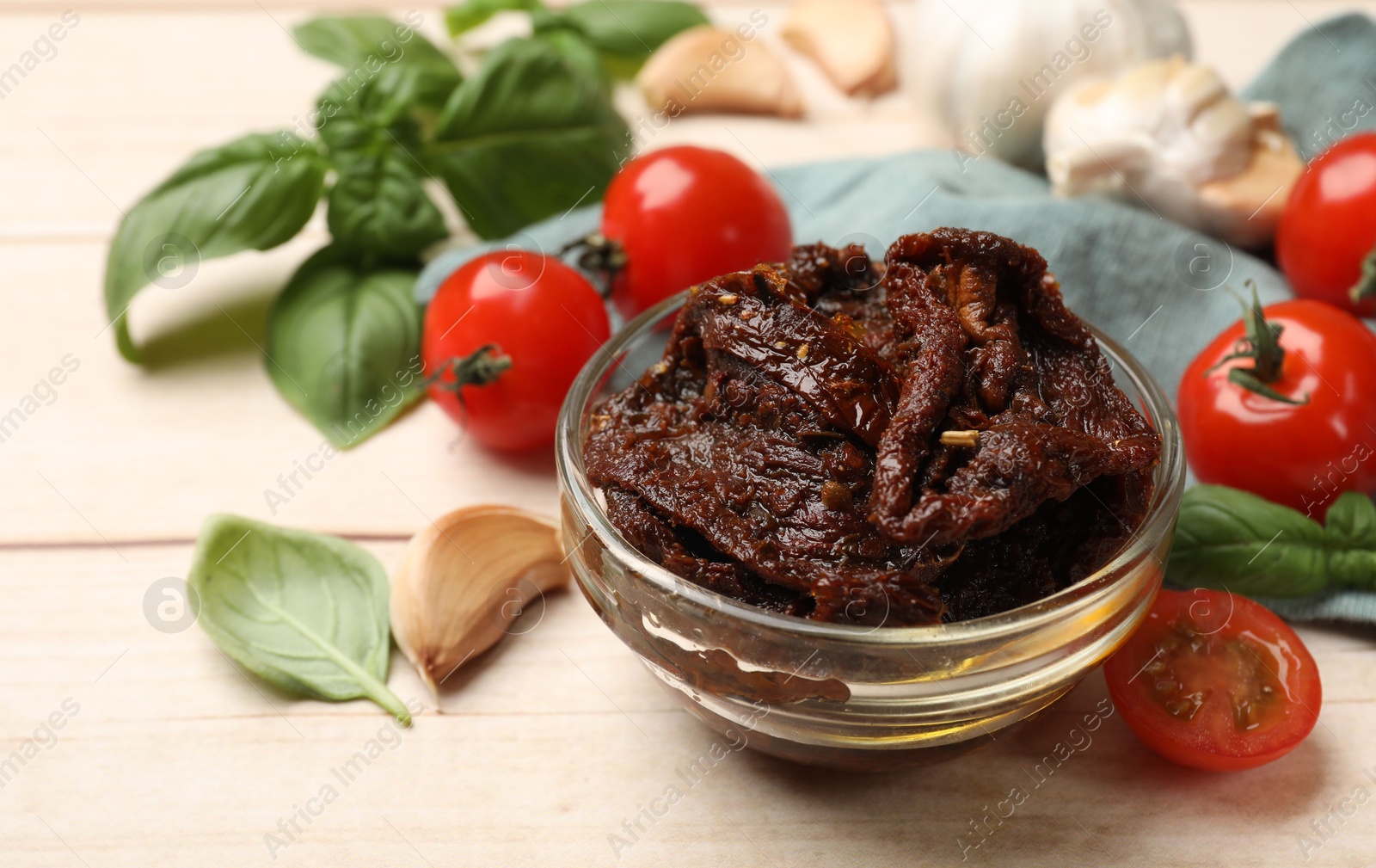 Delicious sun dried tomatoes, fresh vegetables, basil and garlic on white wooden table, closeup Photo of Delicious sun dried tomatoes, fresh vegetables, basil and garlic on white wooden table, closeup
