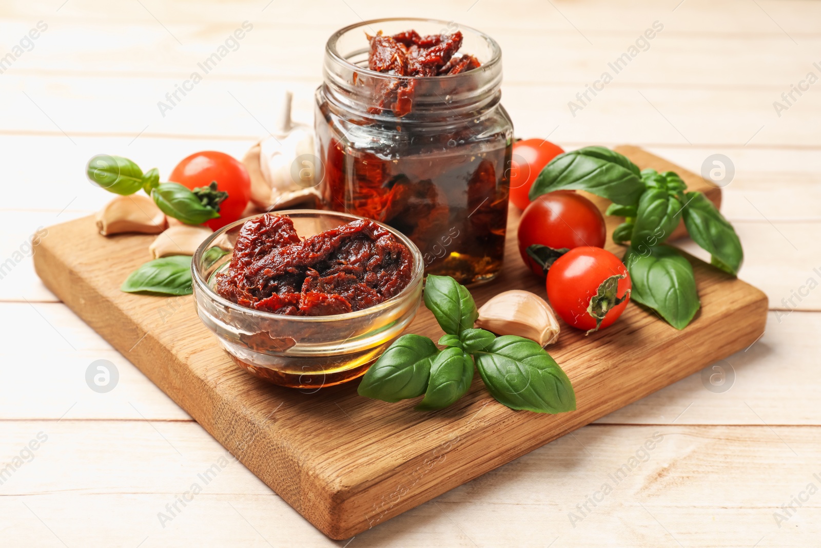 Delicious sun dried tomatoes, fresh vegetables, basil and garlic on white wooden table, closeup Photo of Delicious sun dried tomatoes, fresh vegetables, basil and garlic on white wooden table, closeup