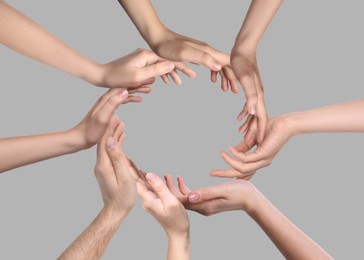 Image of People making circle with their hands on grey background, closeup. Unity, partnership, cooperation