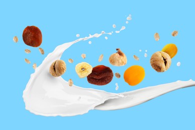 Image of Milk splash with oat flakes and dried fruits on light blue background. Healthy breakfast