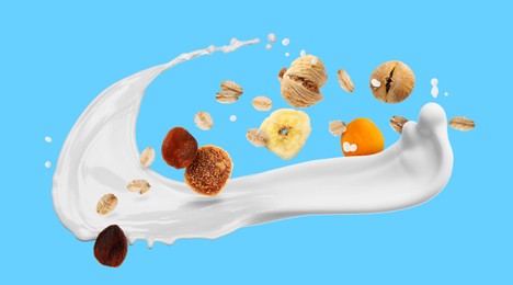 Image of Milk splash with oat flakes and dried fruits on light blue background. Banner design