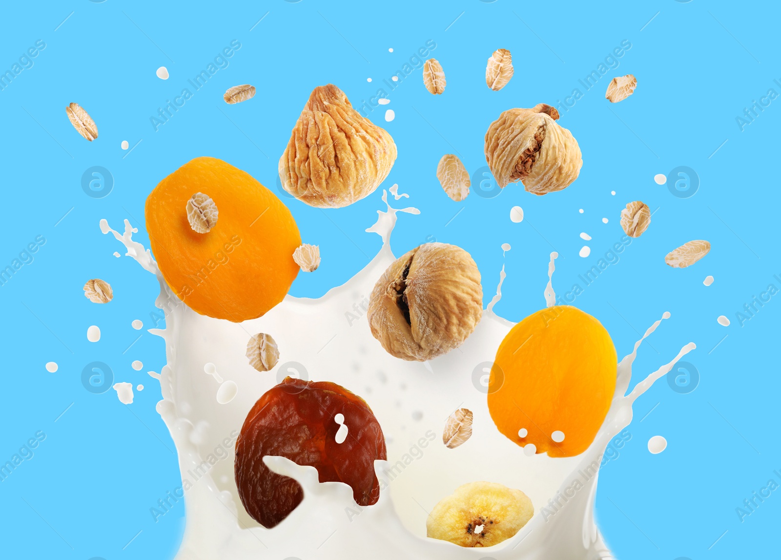 Milk splash with oat flakes and dried fruits in air on light blue background Image of Milk splash with oat flakes and dried fruits in air on light blue background