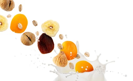 Image of Milk splash with oat flakes and dried fruits in air on white background. Healthy breakfast