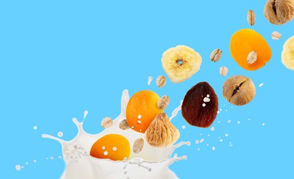 Image of Milk splash with oat flakes and dried fruits in air on light blue background. Banner design
