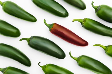 Image of Individuality, uniqueness, different. Red pepper among green ones on white background, flat lay