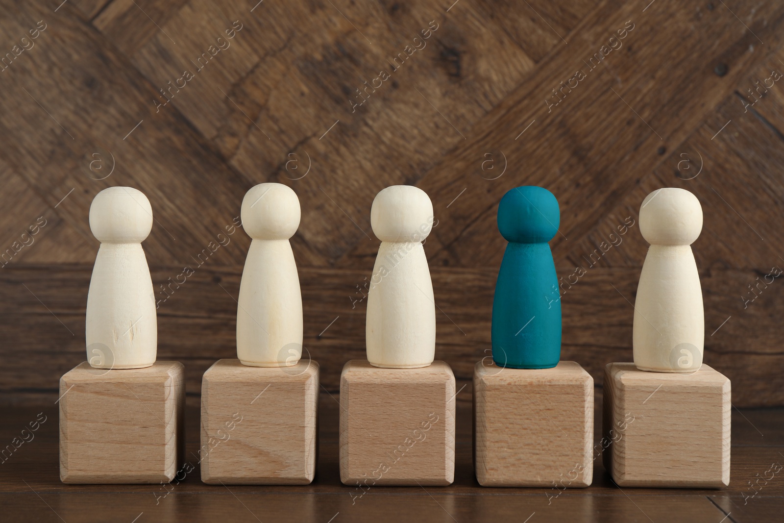 Individuality, uniqueness, different. Blue human figure among colorless ones on cubes against wooden background Image of Individuality, uniqueness, different. Blue human figure among colorless ones on cubes against wooden background