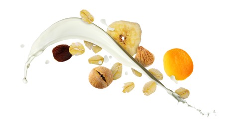 Image of Milk splash with oat flakes and dried fruits on white background. Healthy breakfast