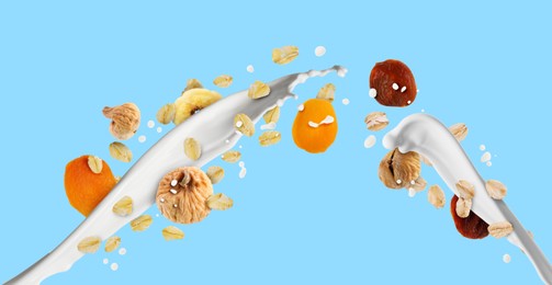 Image of Milk splash with oat flakes and dried fruits on light blue background. Banner design