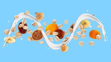 Image of Milk flow with oat flakes and dried fruits on light blue background. Banner design