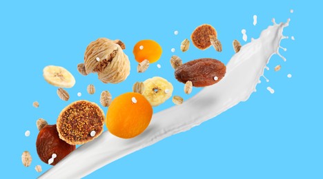 Image of Milk splash with oat flakes and dried fruits on light blue background. Banner design