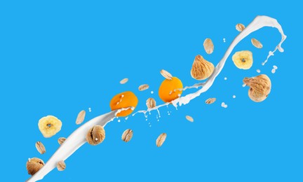 Image of Milk splash with oat flakes and dried fruits on light blue background. Banner design