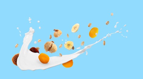 Image of Milk splash with oat flakes and dried fruits on light blue background. Banner design