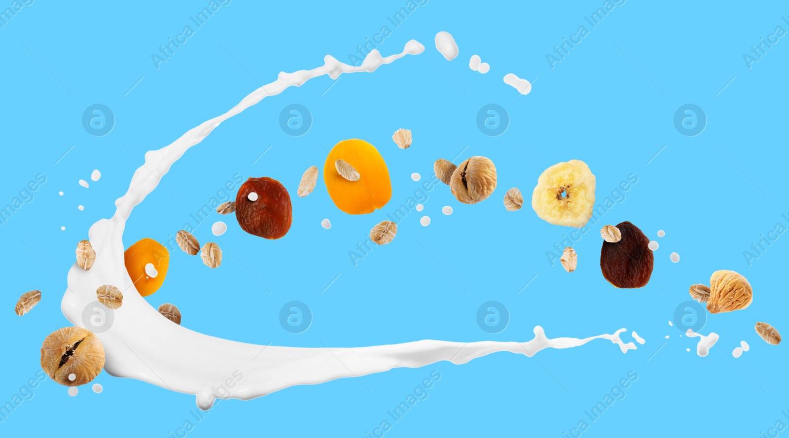 Milk splash with oat flakes and dried fruits on light blue background. Banner design Image of Milk splash with oat flakes and dried fruits on light blue background. Banner design