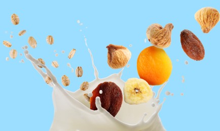 Image of Milk splash with oat flakes and dried fruits in air on light blue background. Banner design