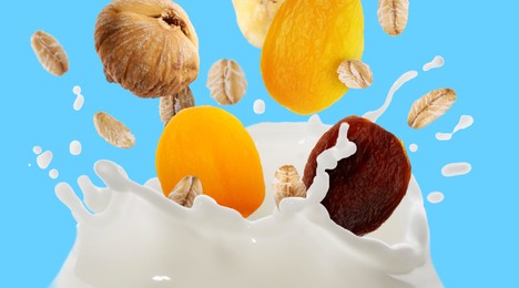 Image of Milk splash with oat flakes and dried fruits in air on light blue background. Banner design
