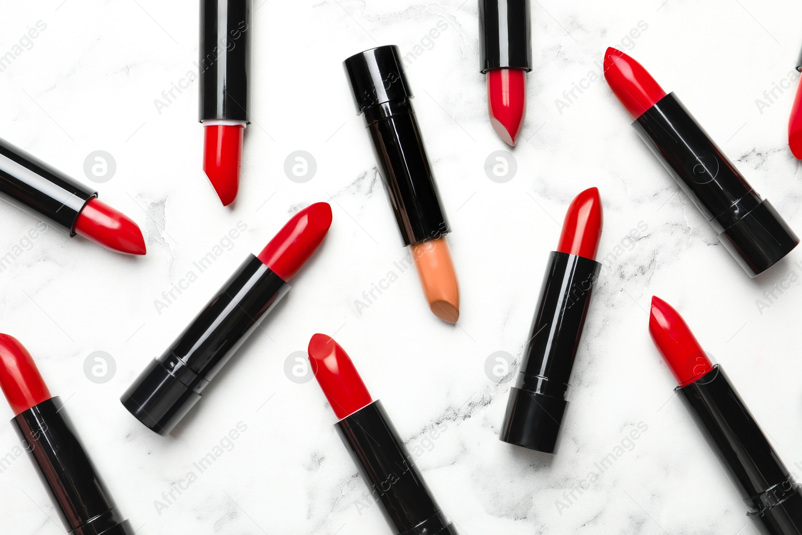 Individuality, uniqueness, different. Nude lipstick among red ones on white marble background, flat lay Image of Individuality, uniqueness, different. Nude lipstick among red ones on white marble background, flat lay