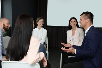 Photo of Business people at seminar in conference room with video projection screen