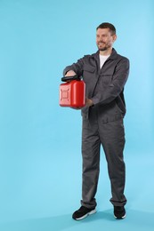 Photo of Man holding plastic canister on light blue background, space for text
