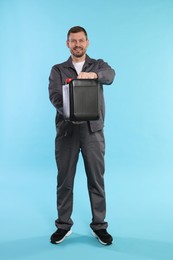 Photo of Man holding plastic canister on light blue background
