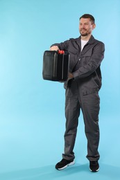 Photo of Man holding plastic canister on light blue background, space for text