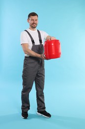 Photo of Man holding plastic canister on light blue background