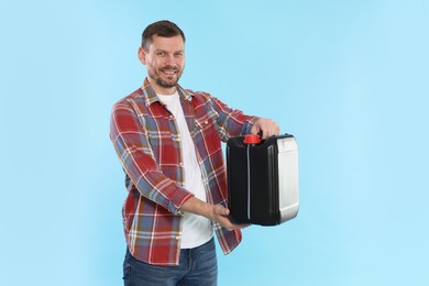 Photo of Man holding plastic canister on light blue background