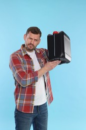 Photo of Man holding plastic canister on light blue background